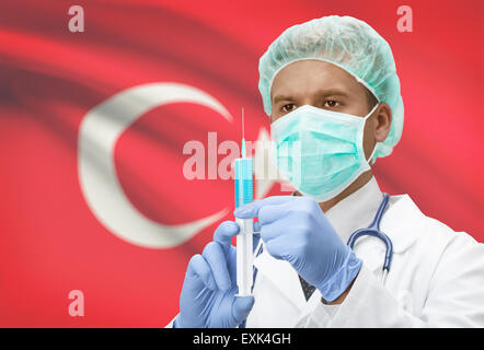 Arzt mit Spritze in Händen und Flagge auf Hintergrund - Türkei Stockfoto