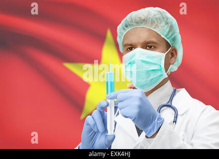 Arzt mit Spritze in Händen und Flagge auf Hintergrund - Vietnam Stockfoto