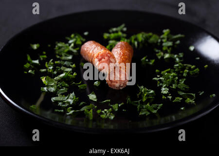 Nahaufnahme von einige dünne geräucherte Wurst auf dunkle Platte Stockfoto