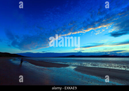 Lough Swilly, County Donegal, Irland. 14. Juli 2015. Irland Wetter: Sonnenuntergang über Lough Swilly County Donegal – 14. Juli 2015. Eine Frau zu Fuß auf Fahan Strand im County Donegal wie die Sonne geht über Lough Swilly. Bildnachweis: George Sweeney/Alamy Live-Nachrichten Stockfoto