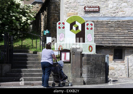 Mutter und Kind eine 2015 Peak District gut Dressing in Bakewell betrachten Stockfoto