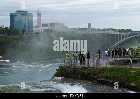 Touristen auf Luna Island blicken auf die amerikanischen Wasserfälle. Bridal Veil Falls Top Wappen im Vordergrund. Niagara Falls, New Yor Stockfoto