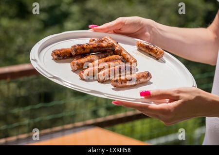Abgebildete nur gekochte Schweinswürstchen ausgestellt in einer Kunststoffplatte statt mit der hand. Stockfoto