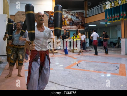 Männer, die schwingende Holzknüppel in den traditionellen Sport des Zurkhaneh, Provinz Isfahan, Kaschan, Iran Stockfoto