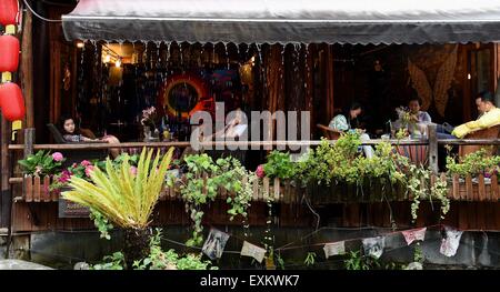 (150715)--LIJIANG, 15. Juli 2015 (Xinhua)--Menschen Rest in einer Bar in Shuhe von Lijiang alte Stadt, der südwestlichen chinesischen Provinz Yunnan, 14. Juli 2015. Als Teil der antiken Stadt Lijiang, die als das Welt-Kulturerbe der UNESCO im Jahr 1997 aufgeführt wurde, zieht Shuhe große Menge an Besuchern.  (Xinhua/Lin Yiguang) (Zwx) Stockfoto