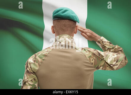 Dunkel-enthäutete Soldat im Hut vor Nationalflagge Reihe - Nigeria Stockfoto