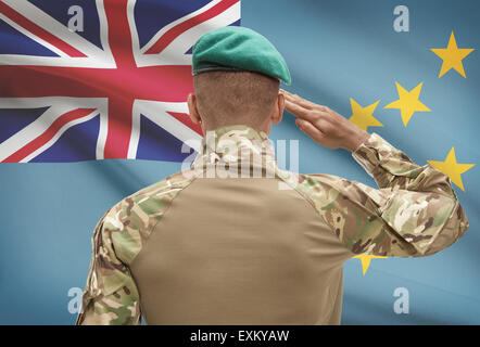 Dunkel-enthäutete Soldat im Hut vor Nationalflagge Reihe - Tuvalu Stockfoto