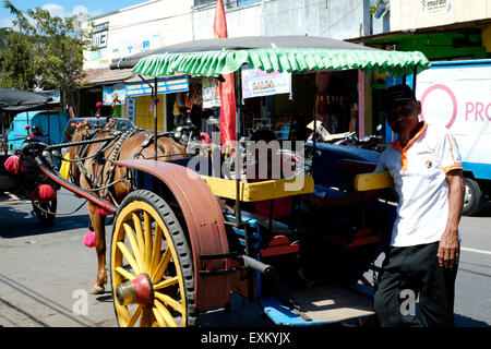 Inhaber eines Dokar Stand neben seinem Schlauch und Wagen warten Fahrpreis zahlenden Personen in Madiun Java Indonesien Stockfoto