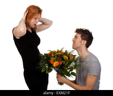 Junger Mann bietet seine Freundin überrascht einen großen Blumenstrauß, isoliert auf weißem Hintergrund Stockfoto