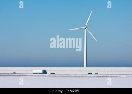 Schneelandschaft mit einer großen Windturbine und eine Autobahn vor Stockfoto