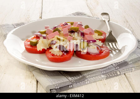 frischer Sommer-Nudelsalat mit Mayonnaise, Tomate, Gurke und Wurst Würfel lila Zwiebel Stockfoto