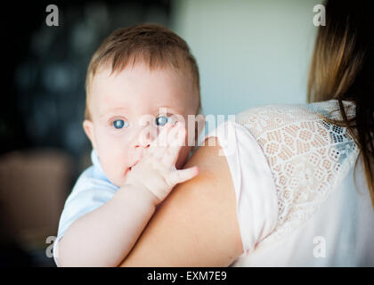 Foto von niedlichen kleinen Jungen auf Mutters Hände Stockfoto