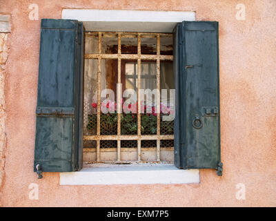 Blick auf einen vergitterten Fenster mit grünen Fensterläden in einem alten Gebäude. Venedig. Italien. Stockfoto