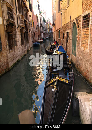 Blick auf eine leere Gondel vertäut in einem engen Kanal in Venedig mit schönen Häusern an den Seiten. Venedig. Italien. Stockfoto