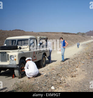 Eine Reifenpanne in der Wüste, Schardscha, Vereinigte Arabische Emirate 1970er Jahre. Reifen-Chang mitten in der Wüste, Sharjah, Vereinigte Arabische Emirate der 1970er Jahre. Stockfoto