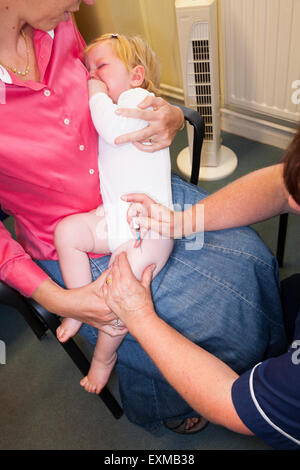 MMR etc. Immunisierung / Impfung / jab / aus einer Spritze in eine einjährige / 12 13 12:13 Monate Baby Oberschenkel / Bein. Stockfoto