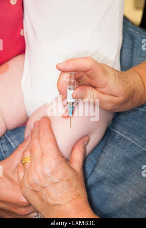 MMR etc. Immunisierung / Impfung / jab / aus einer Spritze in eine einjährige / 12 13 12:13 Monate Baby Oberschenkel / Bein. Stockfoto