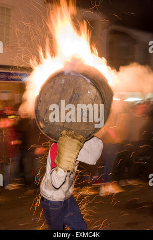 Zwischen brennenden Fass durchgeführt durch die Straße anlässlich Bonfire Night, 5 November, bei den Festspielen Tar Barrel schon St Mary, Devon, England Stockfoto