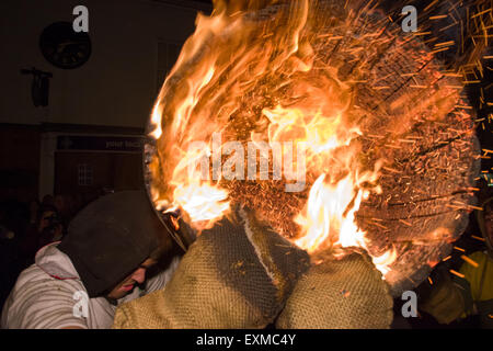 Zwischen brennenden Fass durchgeführt durch die Straße anlässlich Bonfire Night, 5 November, bei den Festspielen Tar Barrel schon St Mary, Devon, England Stockfoto