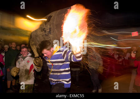 Zwischen brennenden Fass durchgeführt durch die Straße anlässlich Bonfire Night, 5 November, bei den Festspielen Tar Barrel schon St Mary, Devon, England Stockfoto