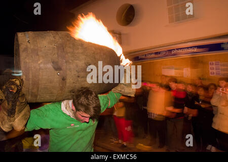 Zwischen brennenden Fass durchgeführt durch die Straße anlässlich Bonfire Night, 5 November, bei den Festspielen Tar Barrel schon St Mary, Devon, England Stockfoto