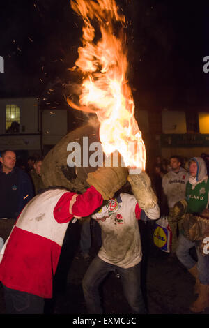 Zwischen brennenden Fass durchgeführt durch die Straße anlässlich Bonfire Night, 5 November, bei den Festspielen Tar Barrel schon St Mary, Devon, England Stockfoto