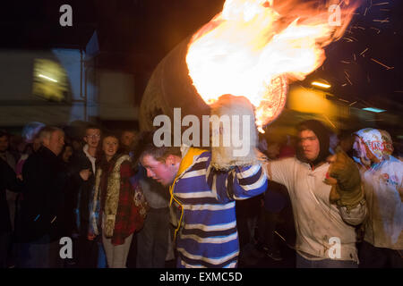 Zwischen brennenden Fass durchgeführt durch die Straße anlässlich Bonfire Night, 5 November, bei den Festspielen Tar Barrel schon St Mary, Devon, England Stockfoto