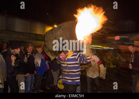 Zwischen brennenden Fass durchgeführt durch die Straße anlässlich Bonfire Night, 5 November, bei den Festspielen Tar Barrel schon St Mary, Devon, England Stockfoto