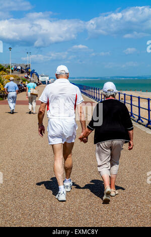 Ein älteres Ehepaar zu Fuß entlang der Strandpromenade, Eastbourne, Sussex, UK Stockfoto