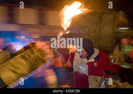 Zwischen brennenden Fass durchgeführt durch die Straße anlässlich Bonfire Night, 5 November, bei den Festspielen Tar Barrel schon St Mary, Devon, England Stockfoto