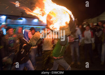 Zwischen brennenden Fass durchgeführt durch die Straße anlässlich Bonfire Night, 5 November, bei den Festspielen Tar Barrel schon St Mary, Devon, England Stockfoto