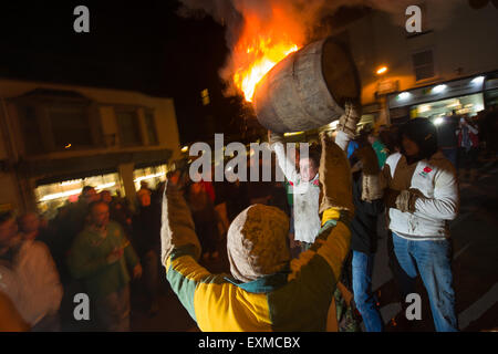 Zwischen brennenden Fass durchgeführt durch die Straße anlässlich Bonfire Night, 5 November, bei den Festspielen Tar Barrel schon St Mary, Devon, England Stockfoto