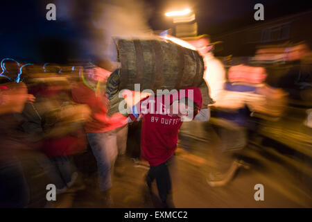 Kind mit einem brennenden Fass anlässlich Bonfire Night, 5 November, bei den Festspielen Tar Barrel schon St Mary, Devon, England Stockfoto