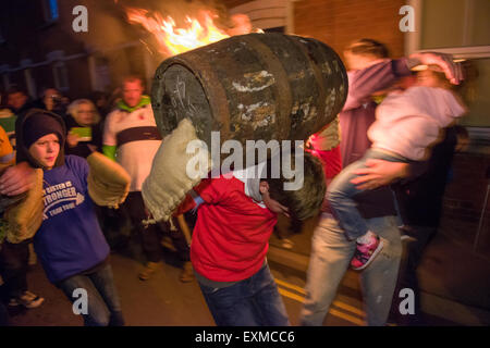 Kind mit einem brennenden Fass anlässlich Bonfire Night, 5 November, bei den Festspielen Tar Barrel schon St Mary, Devon, England Stockfoto