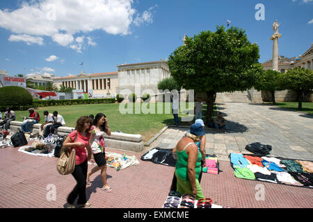 Migrant Straße Handel Verkäufer und ihre Waren auf Anzeige an Menschen vorbei an der Universität Athen/Panepistimiou Street. Athen Stockfoto