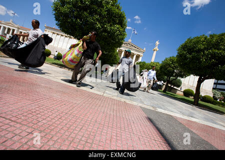 Migrationshintergrund Straßenverkäufer laufen mit ihren waren zu entkommen, Polizei jagt ihnen Panepistimiou Straße der Universität Athen. Stockfoto