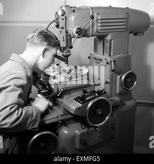 1950er Jahre, historisches Bild zeigt einen jungen männlichen Lehrling mit einer sophiscated Power driven Precision Metal Machine Tool. Eine Werkzeugmaschine ist ein Werkzeug, entweder elektrisch oder handbetrieben für die Bearbeitung von Metall durch Schneiden, Schleifen oder Formen. Stockfoto