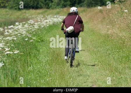Ein Radfahrer fährt entlang einer Strecke am Ufer des den Fluss Mersey wie es verläuft zwischen Didsbury und Northenden in South Manchester. Stockfoto