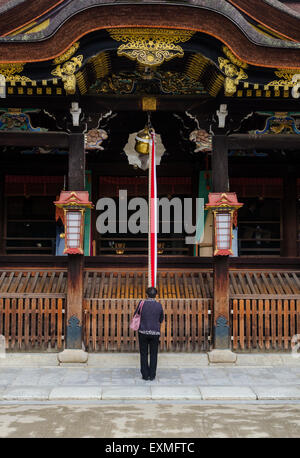 Frau beten vor dem Hauptschrein beim Kitano Tenmangu Schrein, Kyoto, Kansai, Japan Stockfoto