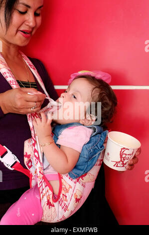 eine Mutter füttert einjähriges Baby Suppe aus einer Fast-Food-Imbiss in Malang Java Indonesien Stockfoto