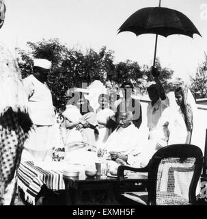 Mahatma Gandhi; sitzend auf einem Tisch; umgeben von Menschen; 1941; Indien nicht Herr Stockfoto