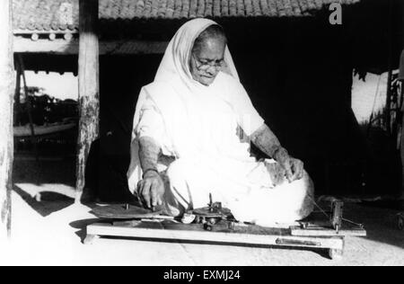 Kasturba Gandhi dreht sich auf Kisan Spinning Wheel, Mahatma Gandhi Ehefrau, Sevagram Ashram, Sewagram, Wardha, Nagpur, Maharashtra, 1940, Indien, Asien, Altes Vintage 1900s Bild Stockfoto