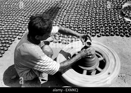 Ein Töpfer sitzt auf seiner Töpferscheibe, wie er Diyas aus Ton für das Diwali-fest in Kumbhaewada gemacht macht; Dharavi Mumbai Stockfoto