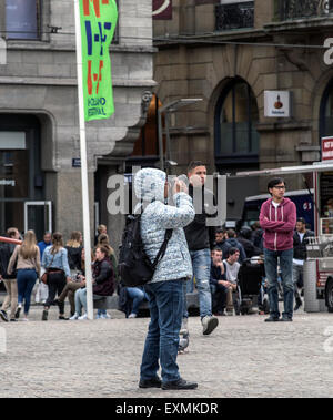 Zufällige Touristen in der Nähe oder am Dam-Platz und den königlichen Palast im Zentrum von Amsterdam, Holland, Niederlande Stockfoto