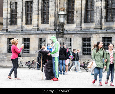 Zufällige Touristen in der Nähe oder am Dam-Platz und den königlichen Palast im Zentrum von Amsterdam, Holland, Niederlande Stockfoto