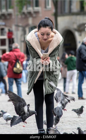 Zufällige Touristen in der Nähe oder am Dam-Platz und den königlichen Palast im Zentrum von Amsterdam, Holland, Niederlande Stockfoto