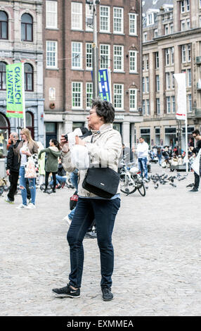 Zufällige Touristen in der Nähe oder am Dam-Platz und den königlichen Palast im Zentrum von Amsterdam, Holland, Niederlande Stockfoto