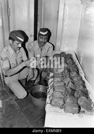 Polizisten, die Prüfung aufgenommenen Schmuggelware Bombay Mumbai Maharashtra, Indien Stockfoto