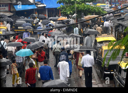 Leute, die mit offenen Schirmen während des Monsunregens laufen; Kurla; Bombay; Mumbai; Maharashtra; Indien; Asien; Asiatisch; Indisch Stockfoto