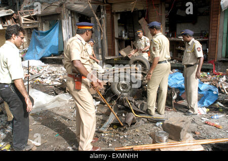 Polizisten untersuchen beschädigt Auto Terror Bombe Explosion Website Zaveri Bazaar Kalbadevi Bombay Mumbai Indien Stockfoto